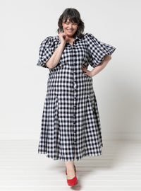Woman wearing the Dallas Woven Dress sewing pattern from Style Arc on The Fold Line. A dress pattern made in washed linen, organza, cotton voile, or lace fabric, featuring a shirt collar, button front, elbow length puff sleeves, godets, pockets, and midi length.