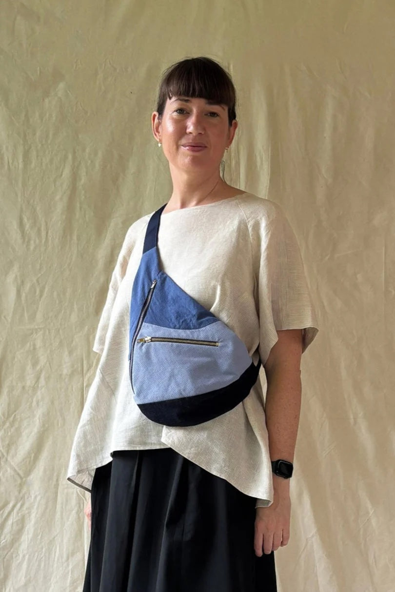 Woman wearing the Darlow Bag sewing pattern from In the Folds on The Fold Line. A crossbody bag pattern made in cotton canvas, cotton drill, denim, or heavyweight nylon fabric, featuring a lining, curved seams, a side zip opening, front zip pocket, and adjustable webbed strap.