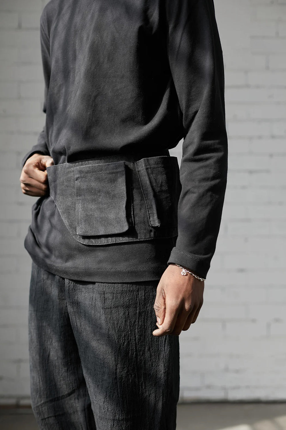 Man wearing the Davis Belt sewing pattern from Elbe Textiles on The Fold Line. A belt bag pattern made in denim or canvas fabric, featuring 3D patch pockets.