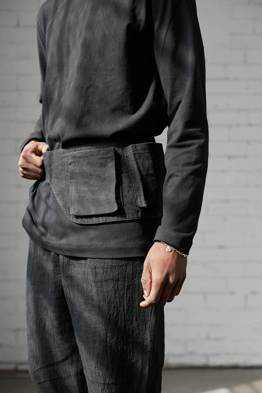 Man wearing the Davis Belt sewing pattern from Elbe Textiles on The Fold Line. A belt bag pattern made in denim or canvas fabric, featuring 3D patch pockets.