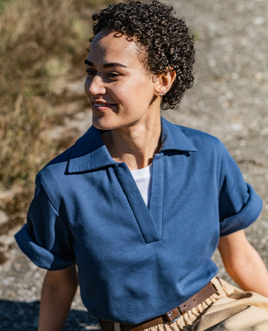 Woman wearing the Dazzle Top sewing pattern from Fibre Mood on The Fold Line. A top pattern made in knit, organza, or denim fabric, featuring a relaxed fit, polo collar, and wide short sleeves.