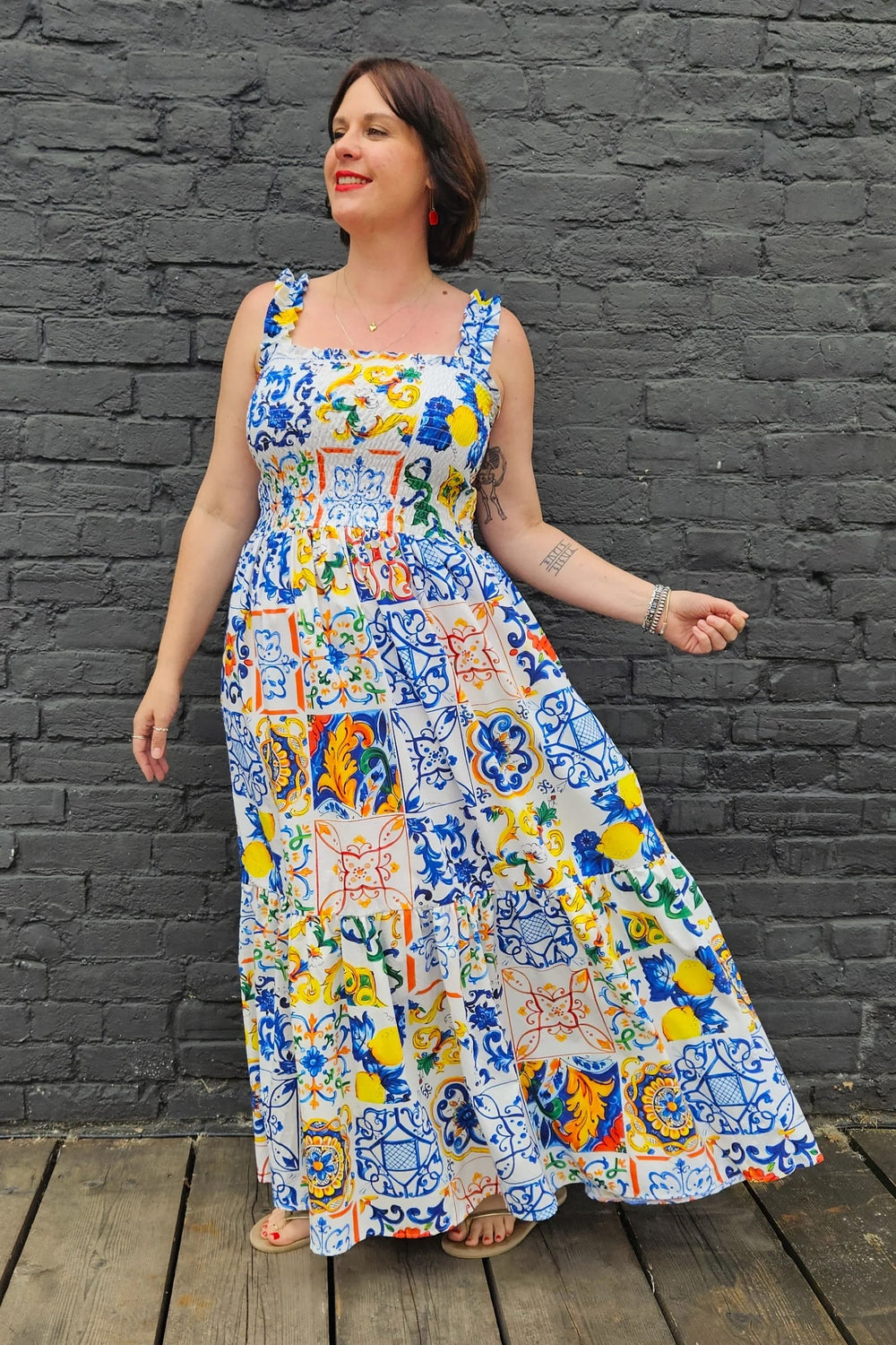 Woman wearing the Delilah Dress sewing pattern from Emporia Patterns on The Fold Line. A sleeveless sundress pattern made in cotton poplin, lawn, double gauze, or seersucker fabric, featuring elasticated straps, a shirred bodice, gathered tiers, and maxi length.