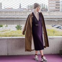 Woman wearing the Deliz Dress sewing pattern from Fibre Mood on The Fold Line. A sleeveless dress pattern made in cotton twill, leather, denim, corduroy, or velvet fabric, featuring a deep V-neckline, bust darts, slit in the centre front, concealed zip in the side seam, and midi length.