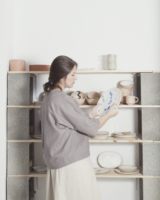 Woman wearing the Diago Blouse sewing pattern from Pauline Alice on The Fold Line. A top pattern made in cotton lawn, linen, viscose, chambray, twill, or crepe fabric, featuring a wide cut, round neckline, 3/4 length dolman sleeves, and a high-low hem finished with facings.