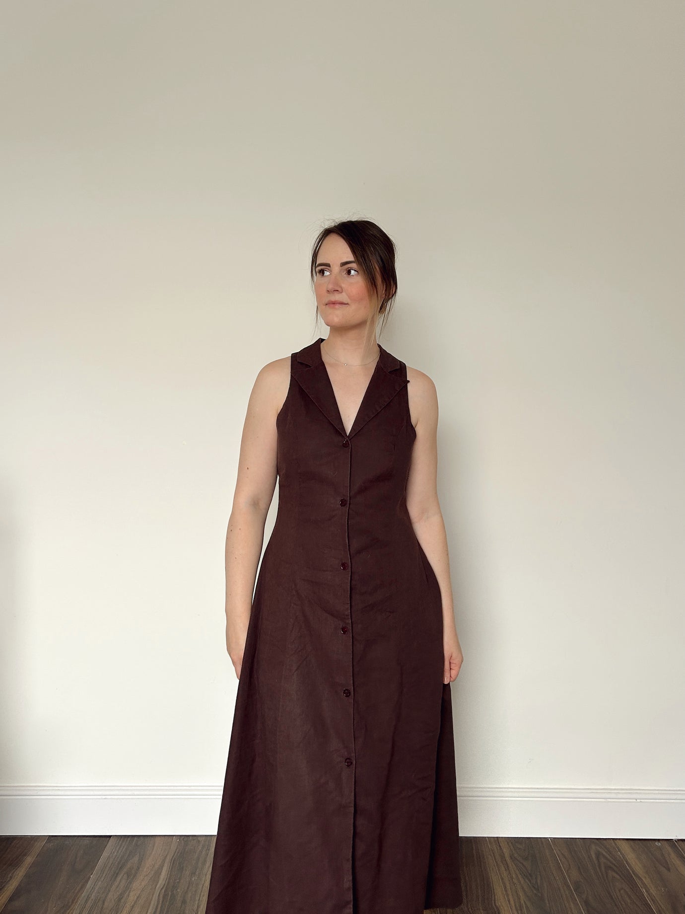 Woman wearing the Diana Dress sewing pattern from NH Patterns on The Fold Line. A sleeveless dress pattern made in cotton shirting, cotton twill, lightweight denim or chambray, linen or linen blend, tencel, or suiting fabric, featuring a lapel and revere neckline, princess seams, button front, and midi length.