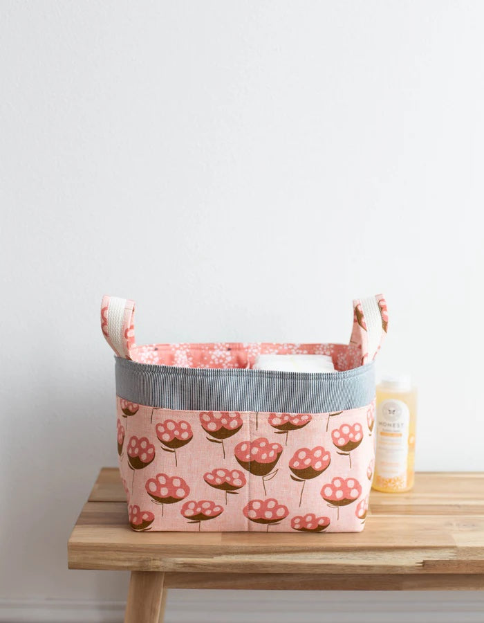 The Divided Basket sewing pattern from Noodlehead on The Fold Line. A structured basket pattern made in quilting cotton or canvas fabric, featuring a divided liner, front pocket, and handles.