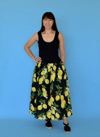 Woman wearing the Dolores Drop-Waist Dress sewing pattern from Nina Lee on The Fold Line. A sleeveless dress pattern made in knit and cotton lawn, poplin, lightweight viscose-linen blend, or rayon fabric, featuring a scoop neckline, gathered A-line skirt, side pockets, and maxi length.