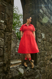 Woman wearing the Dungiven Dress sewing pattern from Sew Liberated on The Fold Line. A dress pattern made in twill, canvas, denim, or pinwale corduroy fabric, featuring a midcentury silhouette, convertible collar, front zip, waist pleats, short sleeves, pockets, and below knee length.