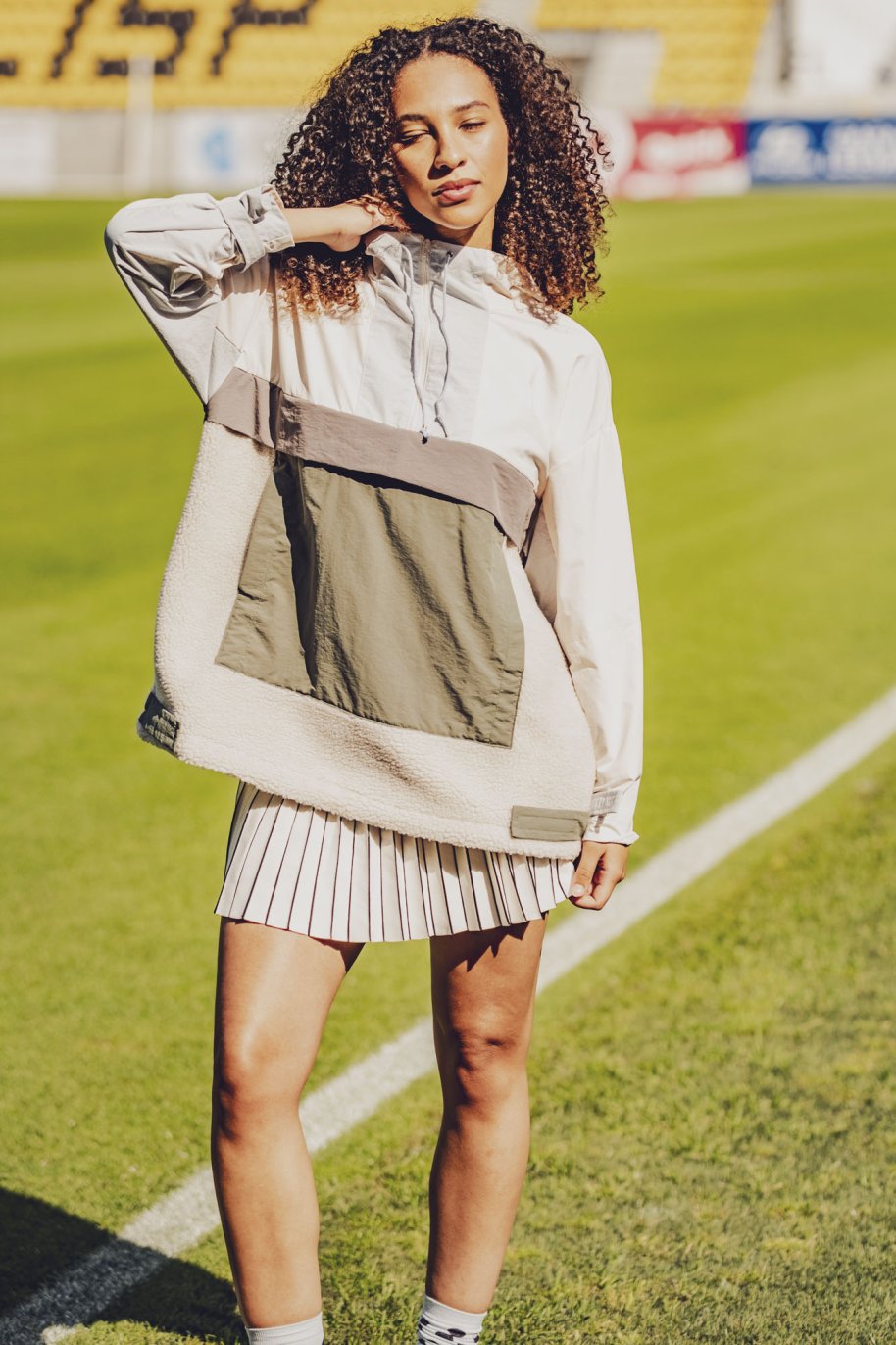 Woman wearing the Dyron Jacket sewing pattern from Fibre Mood on The Fold Line. A windbreaker pattern made in nylon or polyester taffeta, ripstop, or coated woven fabric, featuring a hood, centre front zip, and large patch pocket with a flap.