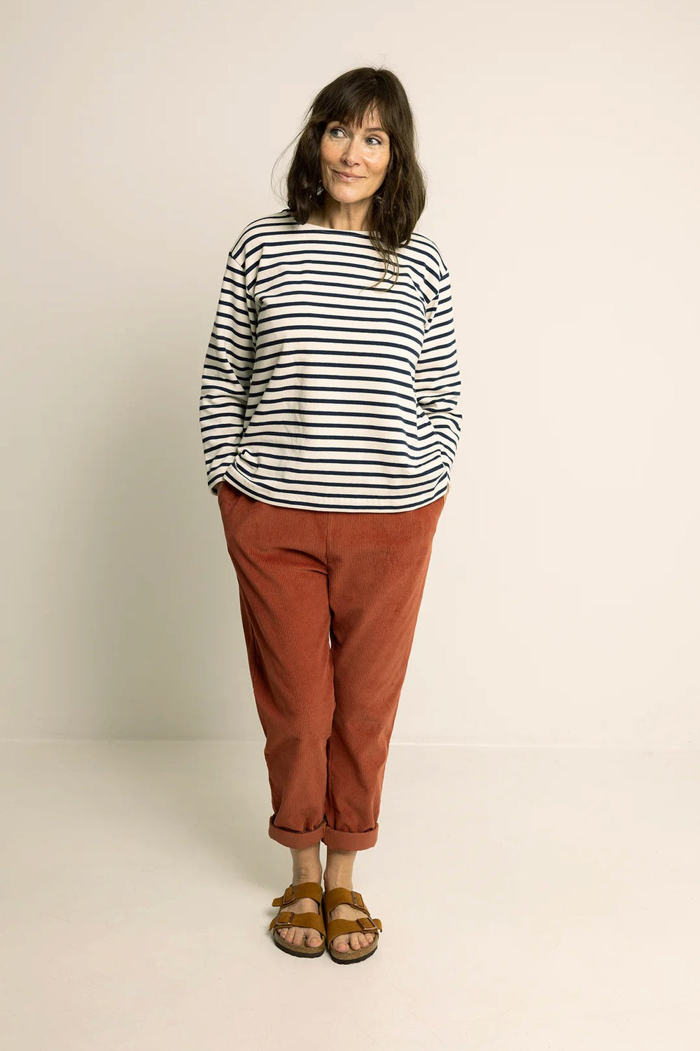 Woman wearing the Easy Pants sewing pattern from Wardrobe by Me on The Fold Line. A trousers pattern made in cotton, viscose, linen, canvas, or denim fabric, featuring a relaxed fit, elasticated waist, side pockets, and cuffed hems.