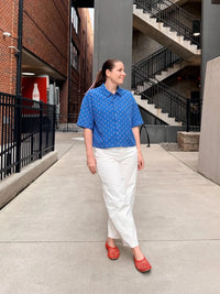 Woman wearing the Easy Rider Shirt sewing pattern from Me & Kiddo Patterns on The Fold Line. A shirt pattern made in cotton, linen, or denim fabric, featuring an oversized boxy fit, dropped shoulders, collar, button front, and short sleeves.