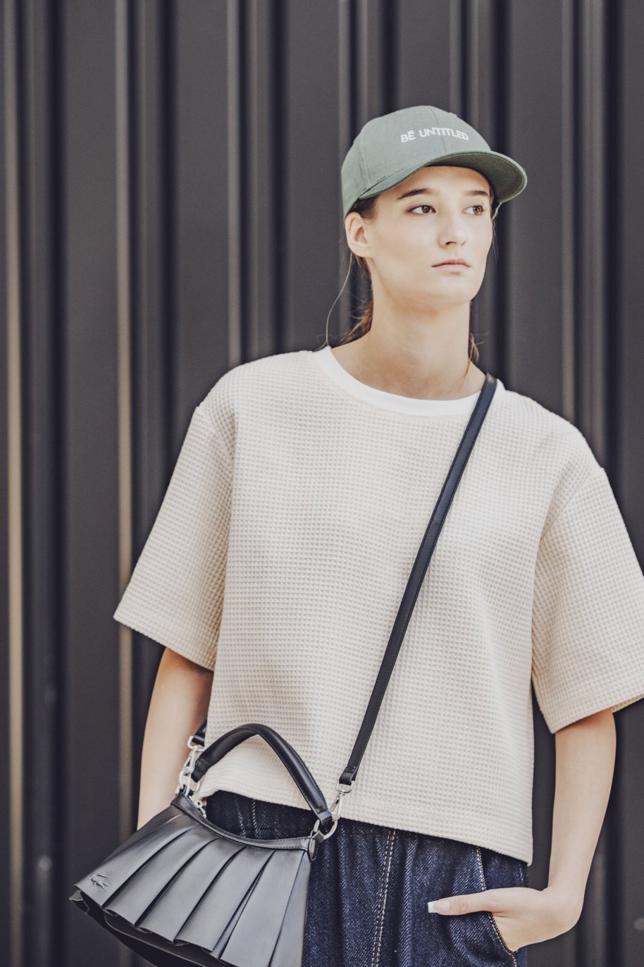 Woman wearing the Elif Top sewing pattern from Fibre Mood on The Fold Line. A T-shirt pattern made in knit or jersey fabric, featuring an oversized fit, round neckline, and elbow length sleeves.