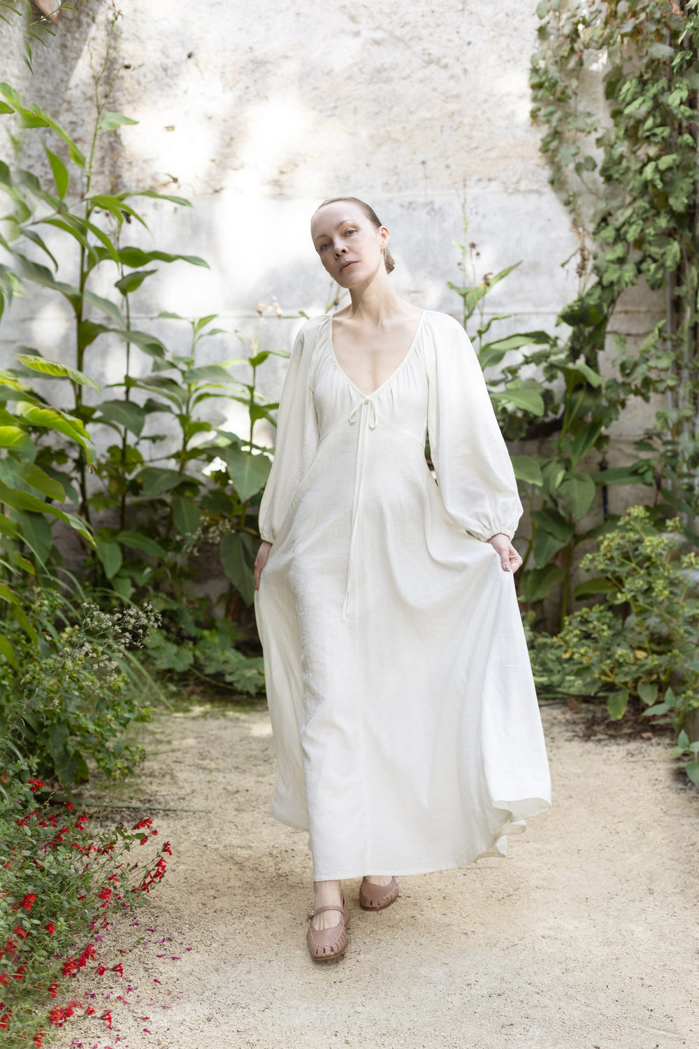 Woman wearing the Ella Dress sewing pattern from Silversaga Patterns on The Fold Line. A dress pattern made in linen, cotton, or block print fabric, featuring a low V-neckline, long voluminous sleeves, and maxi length.