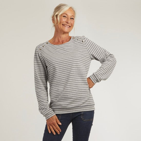 Woman wearing the Ellie Sweatshirt sewing pattern from Coralie Bijasson on The Fold Line. A sweatshirt pattern made in knit fabric, featuring a relaxed fit, round neckline, snaps on the shoulders, and long sleeves.