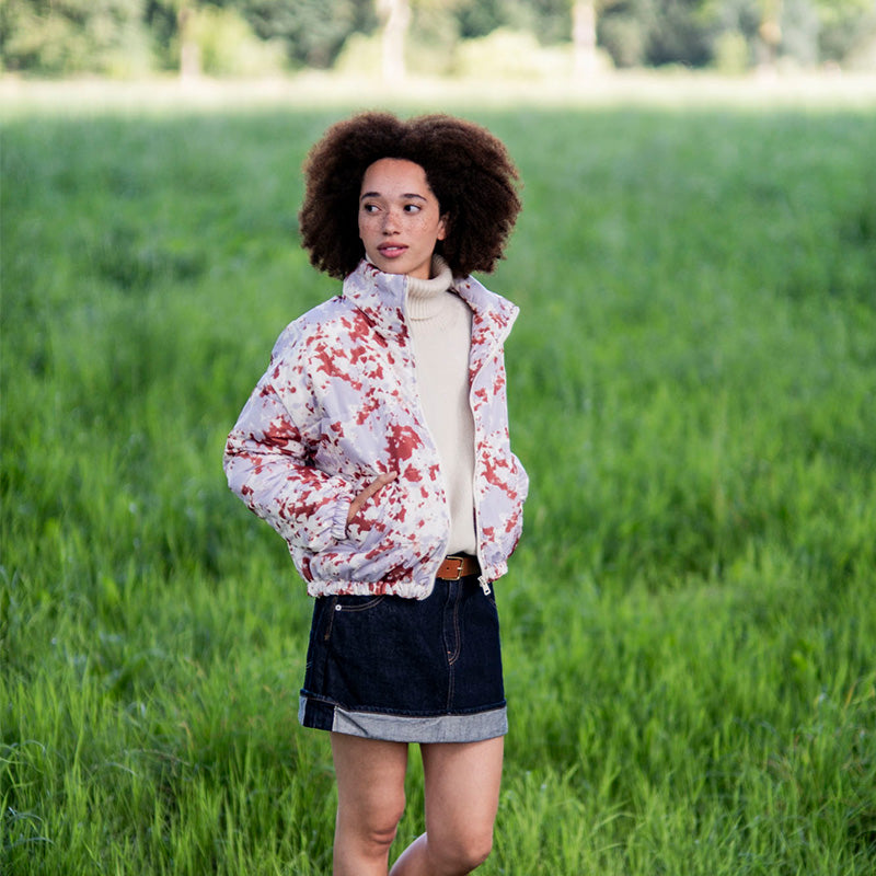 Woman wearing the Elsie Jacket sewing pattern from Fibre Mood on The Fold Line. A lined jacket pattern made in quilted fabric, boiled wool, bouclé, flannel, canvas, or cotton twill fabric, featuring a high collar, front zip, welt pockets, and elasticated cuffs and hem.