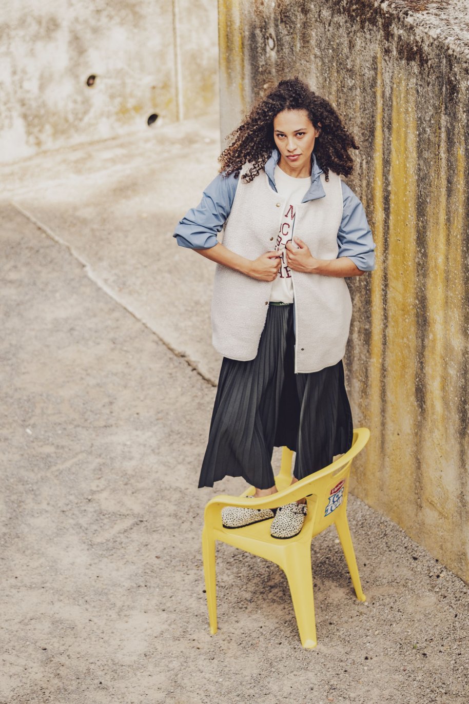 Woman wearing the Ember Bodywarmer sewing pattern from Fibre Mood on The Fold Line. A sleeveless bodywarmer pattern made in teddy (sherpa fleece) fabric, featuring an oversized cut, optional lining, bias bound edges, and snap closures.