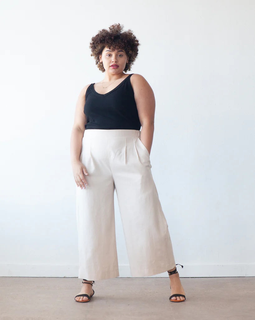 Woman wearing the Emerson Crop Pant and Short sewing pattern from True Bias on The Fold Line. A trousers pattern made in linen, cotton, rayon challis, tencel twill, or chambray fabric, featuring a flat front waistband, elasticised back waistband, front pleats, side pockets, wide leg, and cropped length.