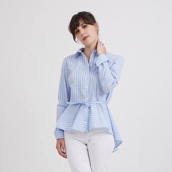 Woman wearing the Emmanuelle Shirt sewing pattern from Coralie Bijasson on The Fold Line. A shirt pattern made in cotton, voile, crepe, or viscose fabric, featuring a collar and collar stand, button front, long sleeves with French cuffs, peplum, and narrow tie belt.
