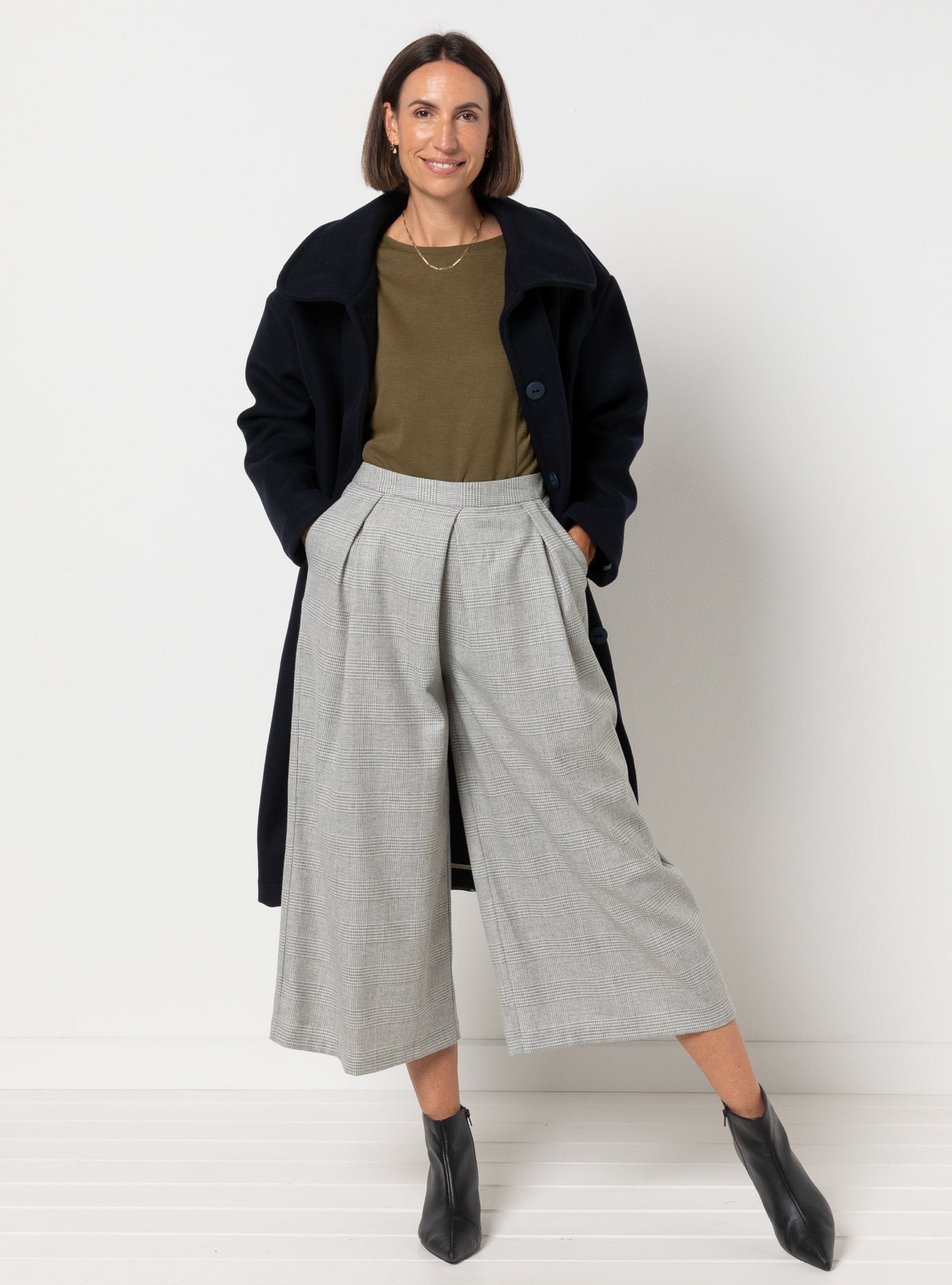 Woman wearing the Erin Woven Culottes sewing pattern from Style Arc on The Fold Line. A trousers pattern made in crepe, rayon, silk, charmeuse, or lightweight wool fabric, featuring a fitted waistband, 3/4 length wide legs, angled front pleats, and angled pockets.