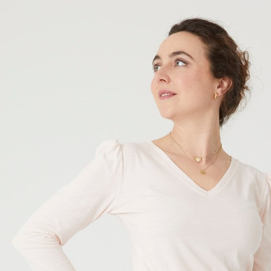 Woman wearing the Essentiel T-shirt sewing pattern from Coralie Bijasson on The Fold Line. A T-shirt pattern made in knit fabric, featuring a V-neckline and long puff sleeves.