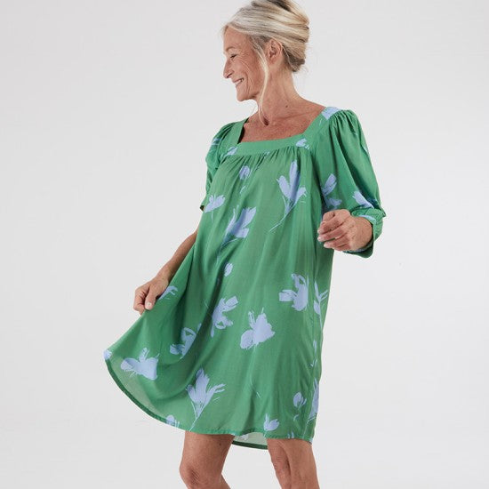 Woman wearing the Ethiopie Dress sewing pattern from Coralie Bijasson on The Fold Line. A dress pattern made in cotton, voile, crepe, or viscose fabric, featuring a square neckline, 3/4 length balloon sleeves with cuffs, gathering on the bodice and sleeves, and side seam pockets.