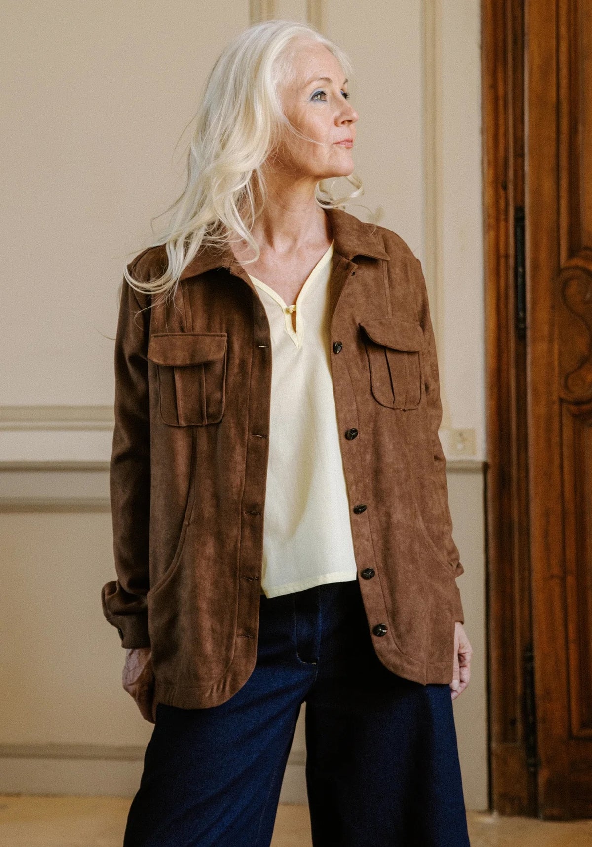 Woman wearing the Ex Libris Overshirt sewing pattern from Maison Fauve on The Fold Line. An overshirt pattern made in dupion, heavier flannel, jacquard, gabardine, denim, or faux suede fabric, featuring a relaxed fit, shirt collar, button front, and pockets.