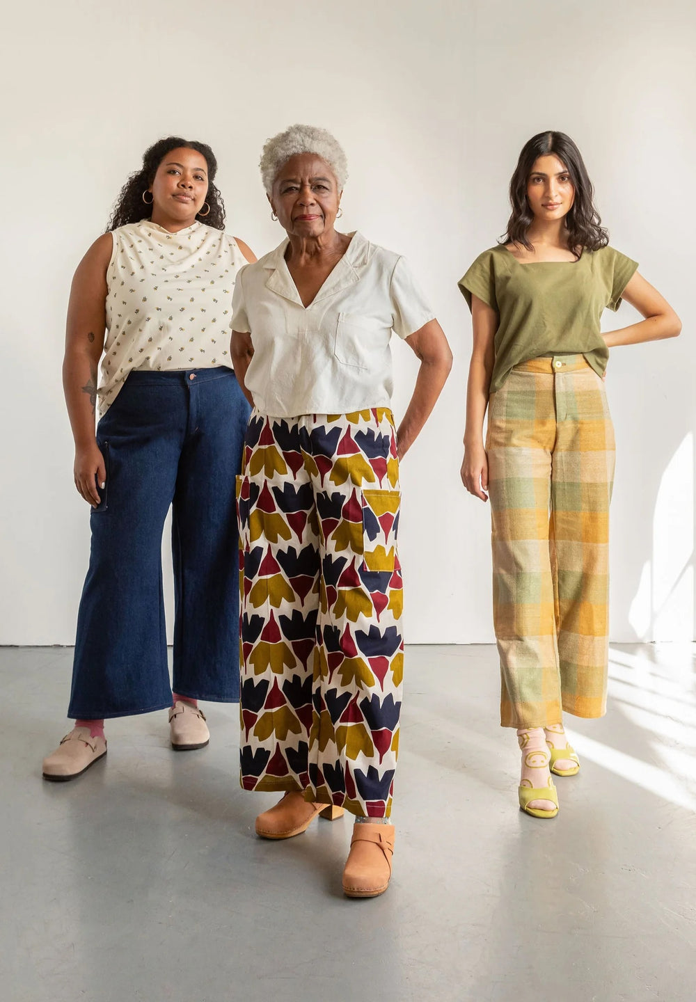 Women wearing the Flâneur Pants sewing pattern from Friday Pattern Company on The Fold Line. A trousers pattern made in cotton canvas, denim, twill, linen, or suiting fabric, featuring a mid-rise, zip fly, flat front, elasticated back, patch pockets, and wide leg.