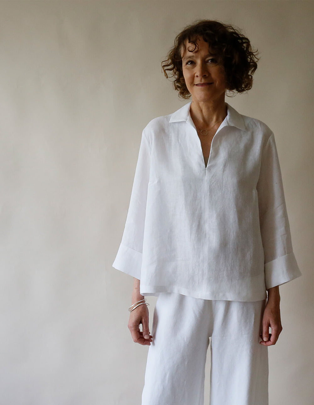 Woman wearing the Flared Shirt sewing pattern from The Maker's Atelier on The Fold Line. A shirt pattern made in cotton, linen, denim, chambray, tencel, or viscose fabric, featuring a relaxed fit, shirt collar, and bracelet length sleeves with a turned back cuff.