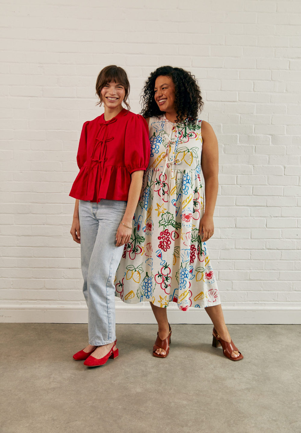 Women wearing the Fleur Dress and Blouse sewing pattern from Fabric Godmother on The Fold Line. A dress and blouse pattern made in cotton poplin, linen, lightweight denim, or brocade fabric, featuring a loose fit, bias finished neckline, optional mid-length sleeves, bow tie closures at the front, and a gathered peplum or skirt.