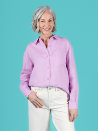 Woman wearing the Frida Shirt sewing pattern from Tilly and the Buttons on The Fold Line. A shirt pattern made in cotton lawn, poplin, dobby, shirting, chambray, flannel, fine needlecord, washed linen, or viscose (rayon) fabric, featuring a relaxed fit, dropped shoulders, button front, two-piece collar and stand, long sleeves pleated into cuffs with plackets, and a curved patch pocket.