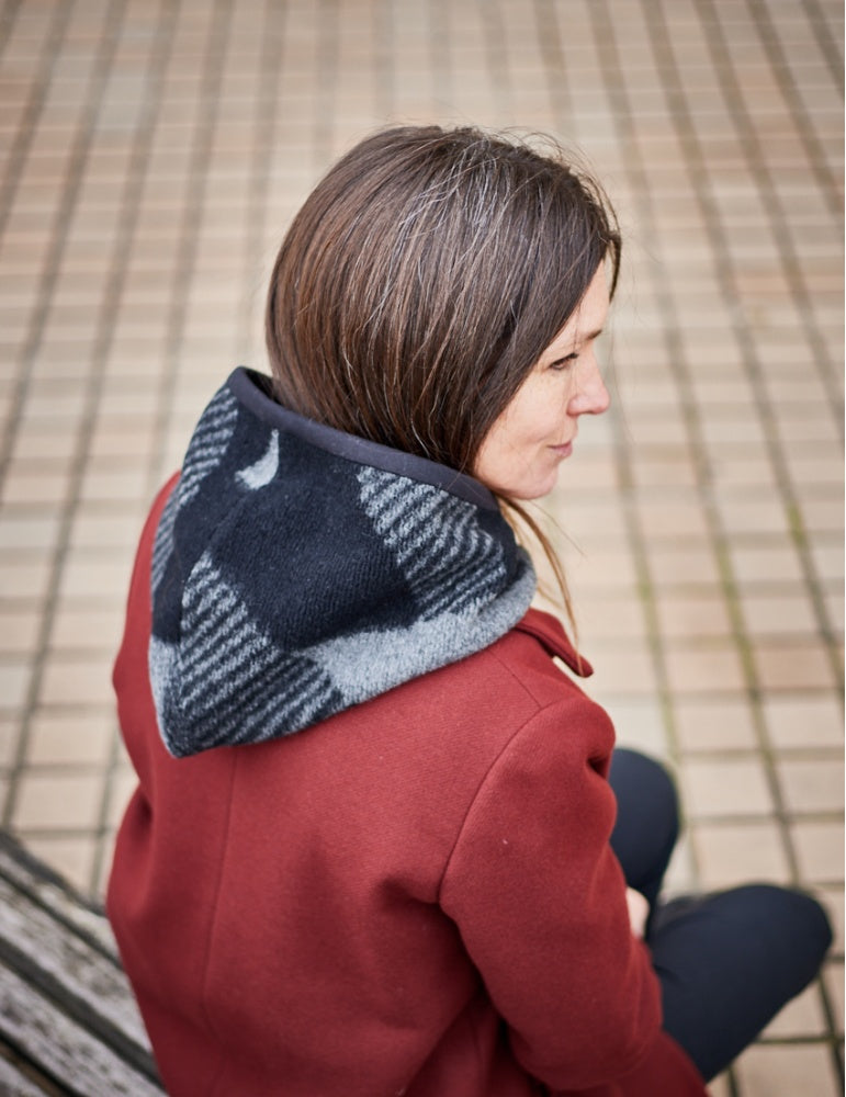 Woman wearing the Frimas Hood sewing pattern from Atelier Scämmit on The Fold Line. A hood pattern made in knit fabric, featuring a bib to slip under your coat.
