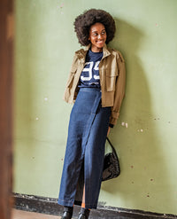 Woman wearing the Fulki Skirt sewing pattern from Fibre Mood on The Fold Line. A skirt pattern made in cotton twill, denim, leather, velvet, or wool fabric, featuring an asymmetric design, button fastening, back darts, patch pockets, decorative topstitching, and maxi length.