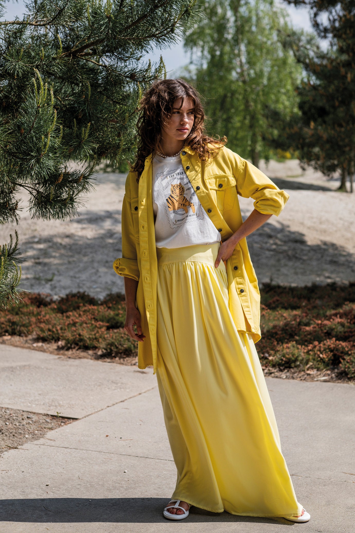 Woman wearing the Gedda Skirt sewing pattern from Fibre Mood on The Fold Line. A maxi skirt pattern made in viscose (crepe), chambray, linen, muslin, nylon, poplin, seersucker, or lyocell fabric, featuring gathers below a yoke and an invisible side zip.