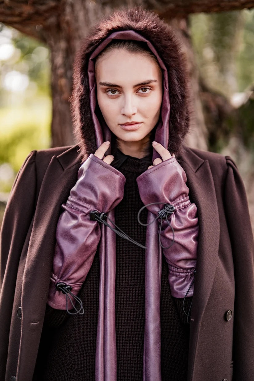 Woman wearing the Gio Gloves sewing pattern from Fibre Mood on The Fold Line. A fingerless glove pattern made in leather, wool, silk, or tulle fabric, featuring thumbholes and elastic cords and cord stoppers.