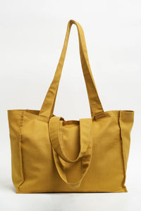 The Grocery Bag sewing pattern from Sew Over It on The Fold Line. A tote bag pattern made in canvas, denim, or cotton drill fabric, featuring two sets of straps and lots of pockets on the inside.