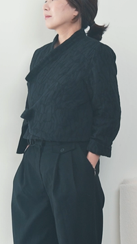 Woman wearing the Hanbok Top and Jacket sewing pattern from Sewing Therapy on The Fold Line. A top or jacket pattern made in linen, cotton, silk, wool, denim, corduroy, bouclé, or tweed fabric, featuring a V-neckline, wrap front, and long sleeves.