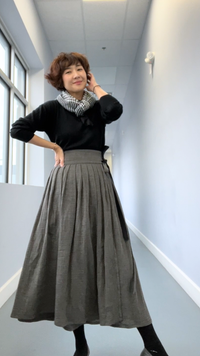 Woman wearing the Hanbok Wrap Skirt sewing pattern from Sewing Therapy on The Fold Line. A wrap skirt pattern made in linen, cotton, or silk fabric, featuring a wide waistband, pleats, and ties.
