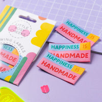 The 'Happiness Is Handmade' woven labels from Little Rosy Cheeks on The Fold Line. The pack includes 6 labels in bright colours ready to be sewn into your handmade clothes.