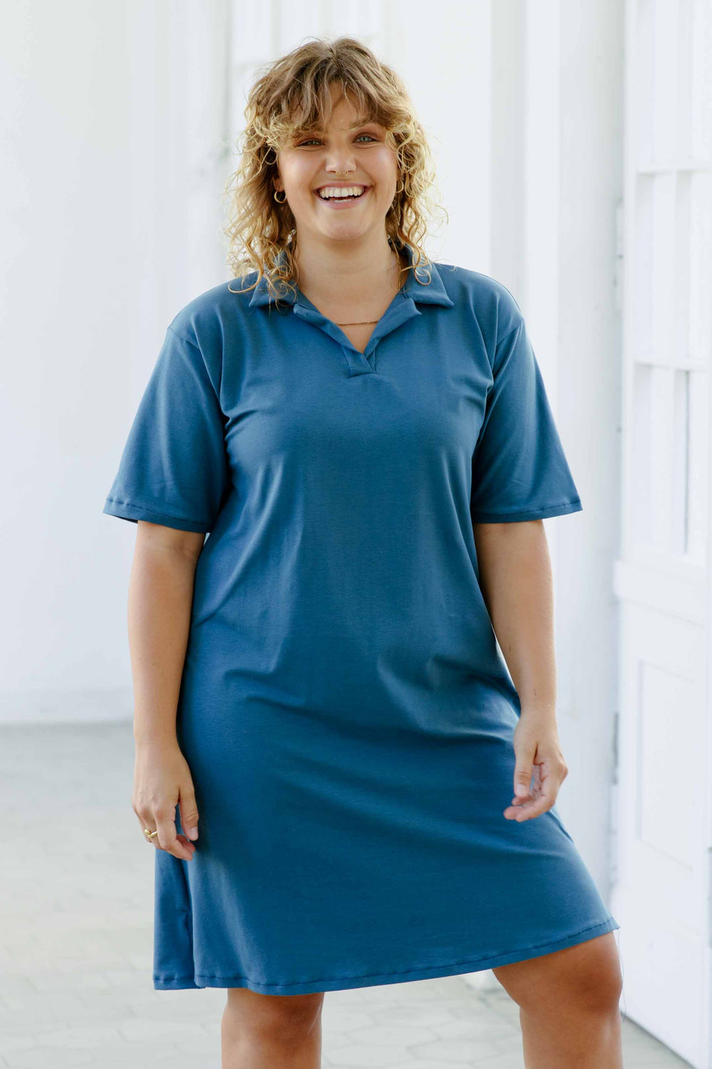 Woman wearing the Harper Polo Dress sewing pattern from JULIANA MARTEJEVS on The Fold Line. A dress pattern made in cotton jersey knit fabric, featuring a classic polo collar, short sleeves, and side slits.
