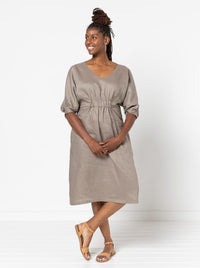 Woman wearing the Harry Woven Dress sewing pattern from Style Arc on The Fold Line. A dress pattern made in linen, rayon, silk, or crepe fabric, featuring a slight A-line shape, soft V neck, elastic detail on the front, elbow length dolman sleeves with tucks, and below knee length.