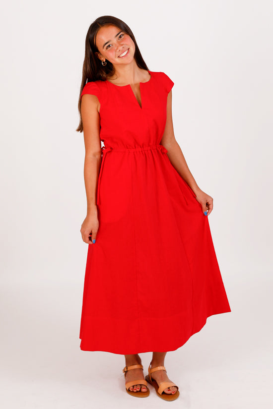 Woman wearing the Hayes Dress sewing pattern from Chalk and Notch on The Fold Line. A dress pattern made in rayon challis, rayon twill, rayon voile, cotton block prints, cotton lawn, cotton poplin, linen, or chambray fabric, featuring cap sleeves, a front neckline slit, adjustable waist with drawstrings, panelled A-line skirt, in-seam pockets, and maxi length.