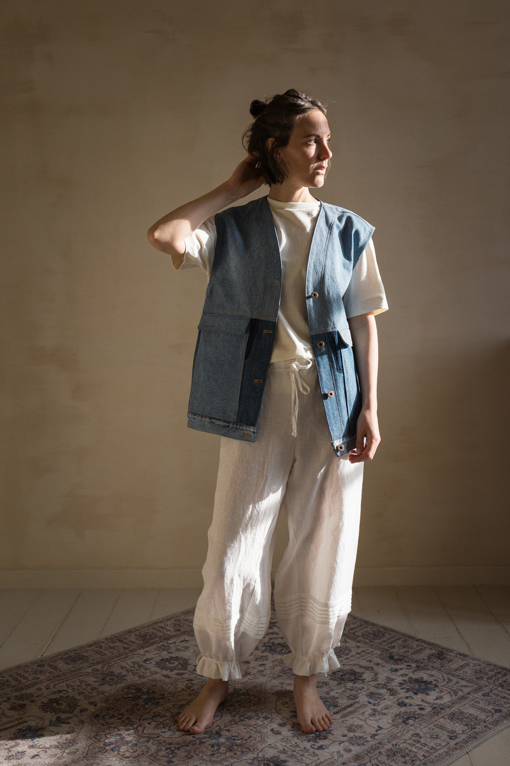 Woman wearing the Hendrix Sleeveless Jacket sewing pattern from Ready to Sew on The Fold Line. A sleeveless jacket or vest pattern made in denim, cotton gabardine, cotton twill or canvas, moleskin, heavyweight flannel, wool coating, corduroy, heavyweight hemp or linen, or quilted cotton fabric, featuring a loose fit, wide armholes, button front, and patch pockets.