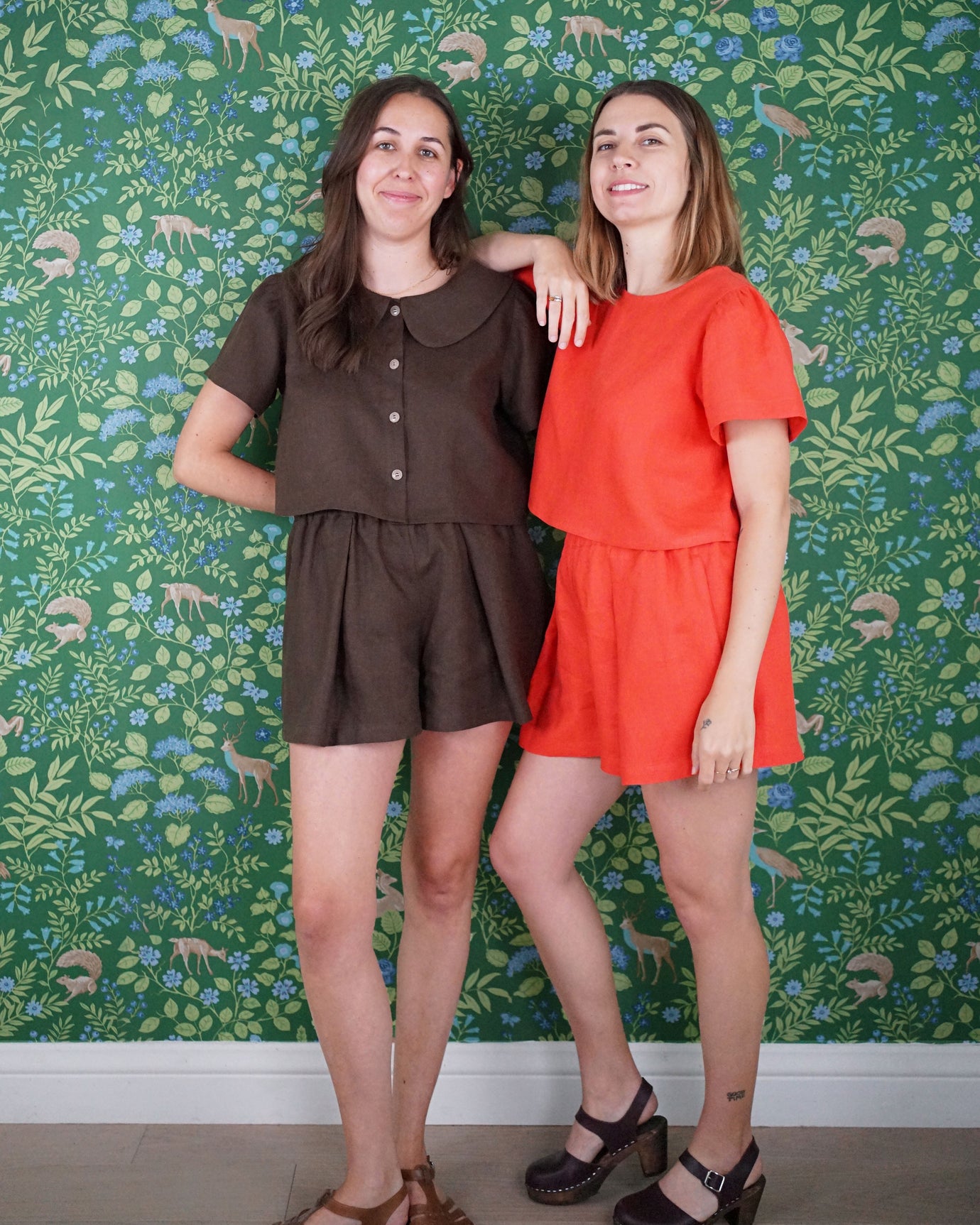 Women wearing the High Tide Set sewing pattern from Matchy Matchy Sewing Club on The Fold Line. A top and shorts pattern made in linen, cotton, or rayon fabric, featuring a top with a round neckline, optional Peter Pan collar, optional button front, and micro puff sleeves and high waisted shorts with an elastic waist, pleats, and pockets.