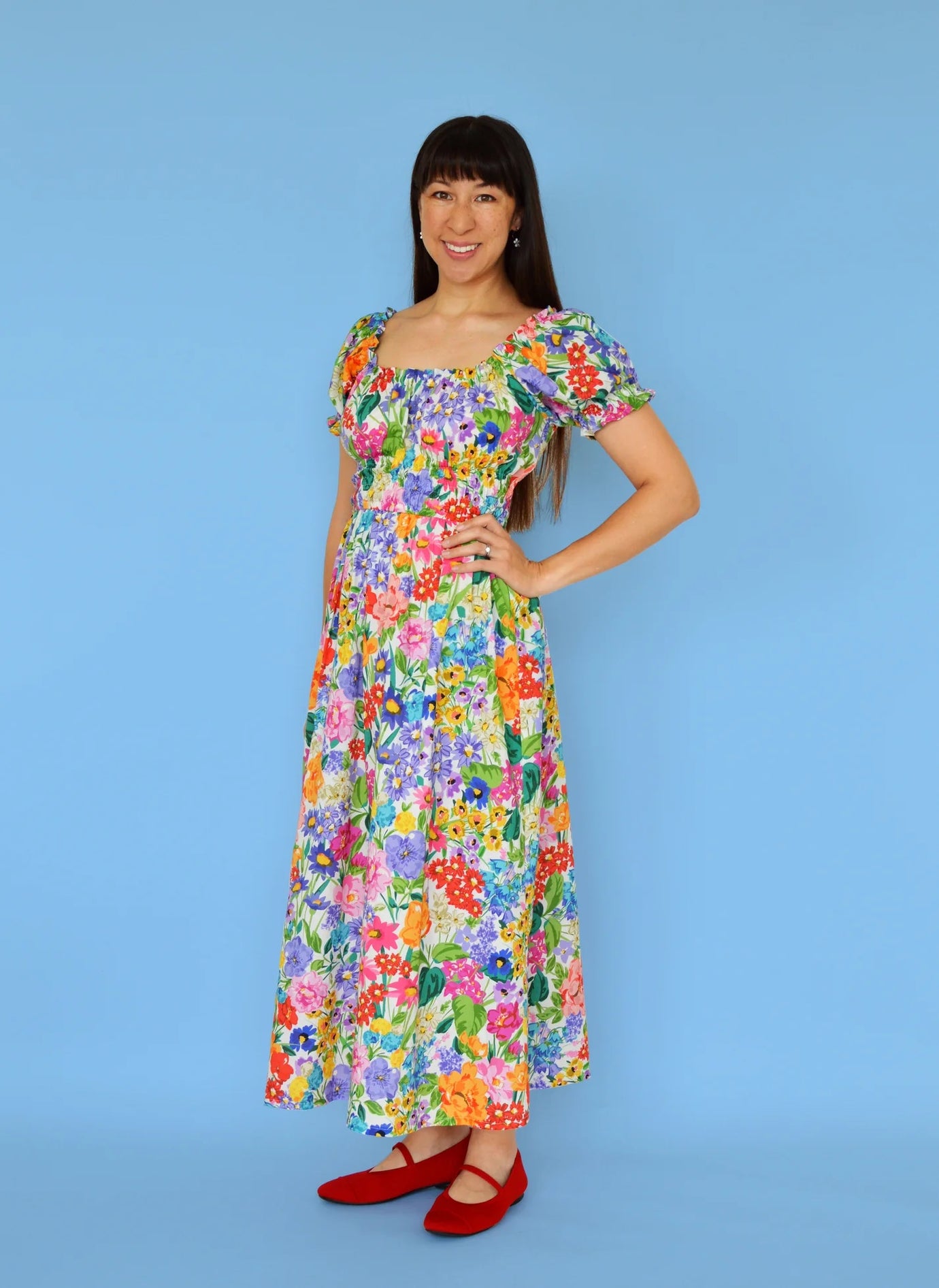 Woman wearing the Holland Park Dress sewing pattern from Nina Lee on The Fold Line. A dress pattern made in cotton lawn, lightweight linen, or rayon fabric, featuring a gathered neckline, short gathered sleeves, elastic waist, and maxi length.