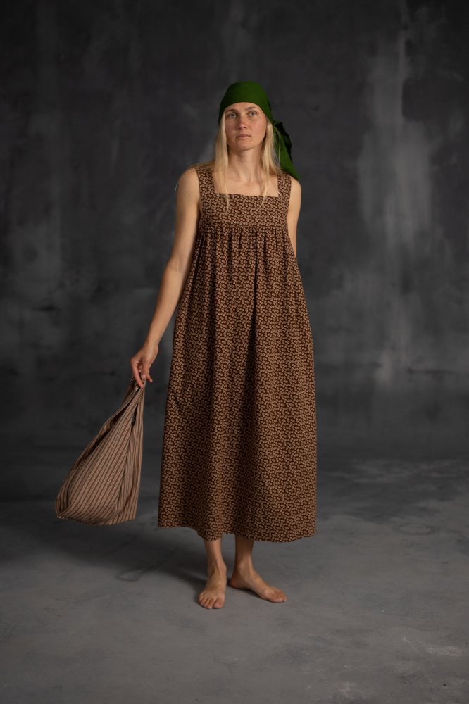 Woman wearing the Honey Dress sewing pattern from Merchant & Mills on The Fold Line. A sundress pattern made in linen, chambray, seersucker, cotton lawn, cotton poplin, tencel, or Indian handloom fabric, featuring wide straps, a mitred bodice, and gently elasticated back.