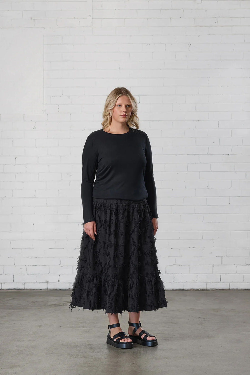 Woman wearing the Howerdel Skirt sewing pattern from Elbe Textiles on The Fold Line. A skirt pattern made in rayon, silk, washed linen, or soft cotton fabric, featuring a fitted waist, gathered tiers, and midi length.