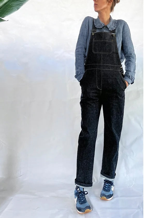 Woman wearing the Huxley Dungarees sewing pattern from French Navy on The Fold Line. A dungarees pattern made in denim, cotton twill, corduroy, or linen fabric, featuring a slim fit, adjustable shoulder straps, five pockets, side button plackets, and a straight leg.