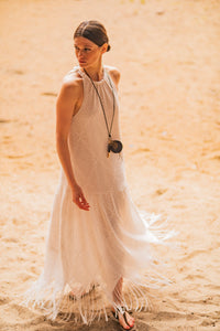Woman wearing the Jax Dress sewing pattern from Fibre Mood on The Fold Line. A sleeveless dress pattern made in poplin, linen, twill, double gauze, chambray, or seersucker fabric, featuring a tie through a casing at the neckline, open back, dropped waist, and maxi length.