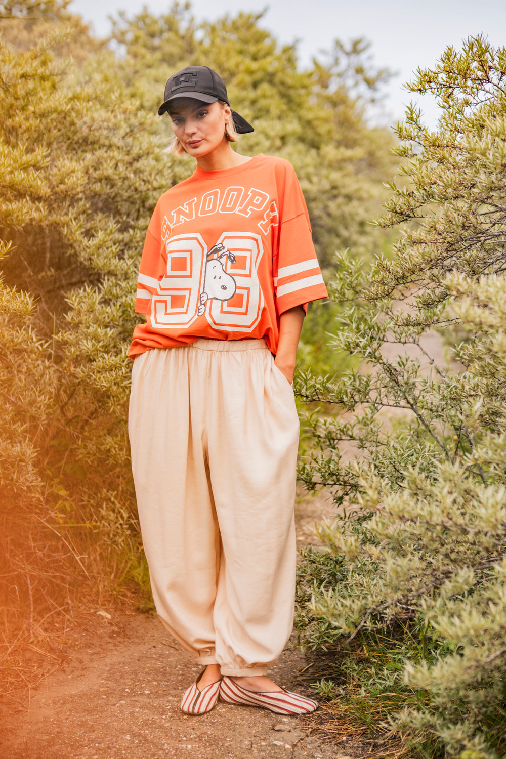 Woman wearing the Josse Trousers sewing pattern from Fibre Mood on The Fold Line. A harem pants pattern made in poplin, chambray, organza, linen, viscose (crepe), or lyocell fabric, featuring a loose fit, dropped crotch, elastic waist, gathers at the waist and ankles, and side pockets.