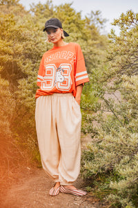Woman wearing the Josse Trousers sewing pattern from Fibre Mood on The Fold Line. A harem pants pattern made in poplin, chambray, organza, linen, viscose (crepe), or lyocell fabric, featuring a loose fit, dropped crotch, elastic waist, gathers at the waist and ankles, and side pockets.